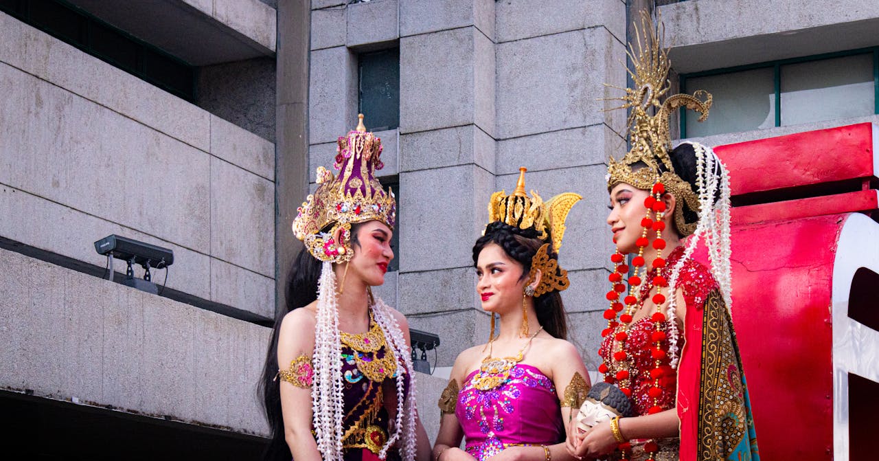 Three women in vibrant traditional Indonesian attire captured during a cultural festival in West Java.
